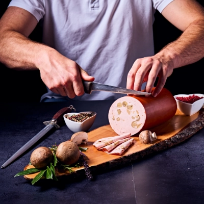 Metzgerei Thumm Filderstadt-Frisches Fleisch und andere regionale Produkte-Grid_6 Aufschnitt von hausgemachter Fleischwurst mit Pilzen und Paprika, frische Metzgerware auf Holzbrett angerichtet