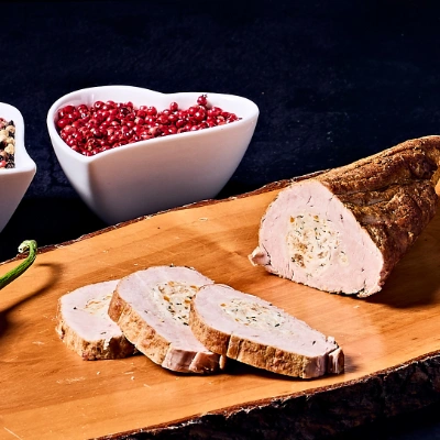Hausgemachte Schweinerolle mit Gemüse – zartes Schweinefleisch mit feiner Gemüseeinlage, aufgeschnitten auf rustikalem Holzbrett